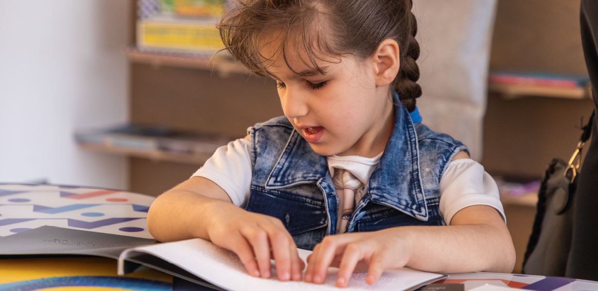 A young girl reader braille book