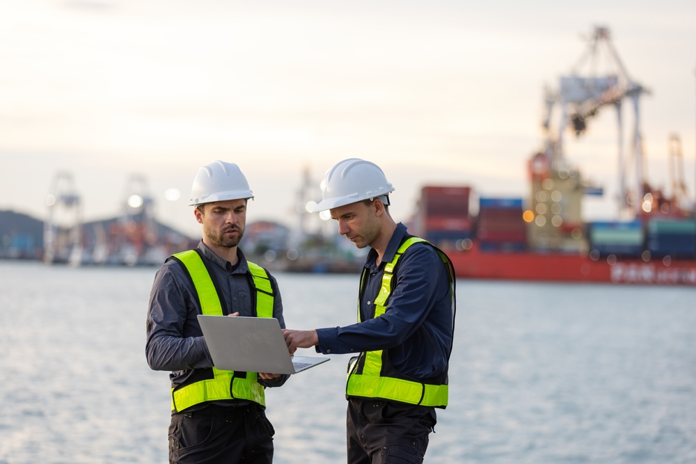 Two Shipping Engineers In Safety Vests And Hard Hats